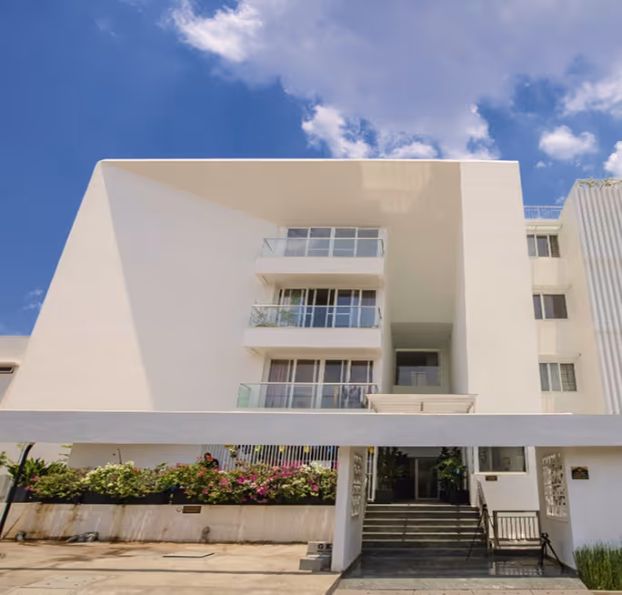 Blessed from the forecourt, its balconies stepping back above a planted base.