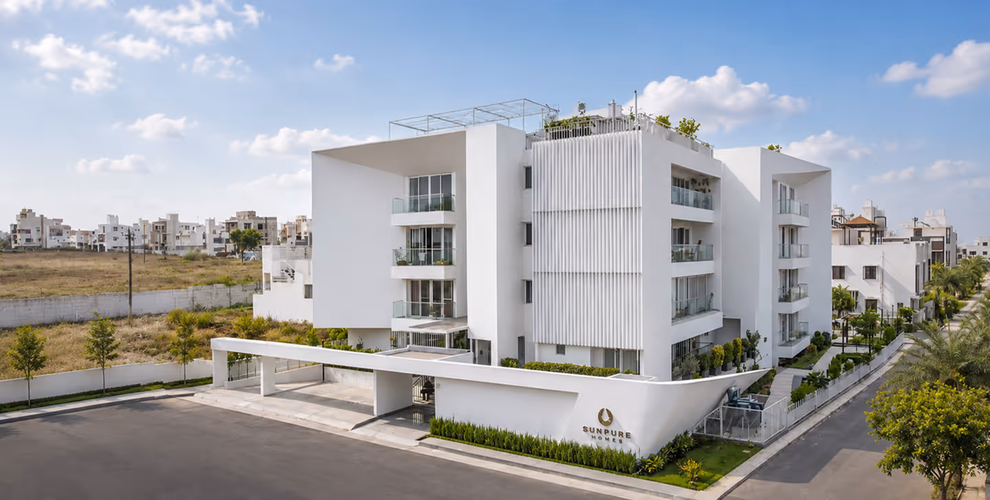 The Blessed apartment block in white render, seen from the entrance road.